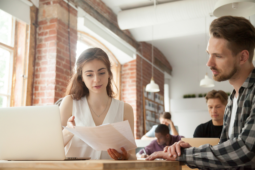 Woman discussing a performance review with a male employee.